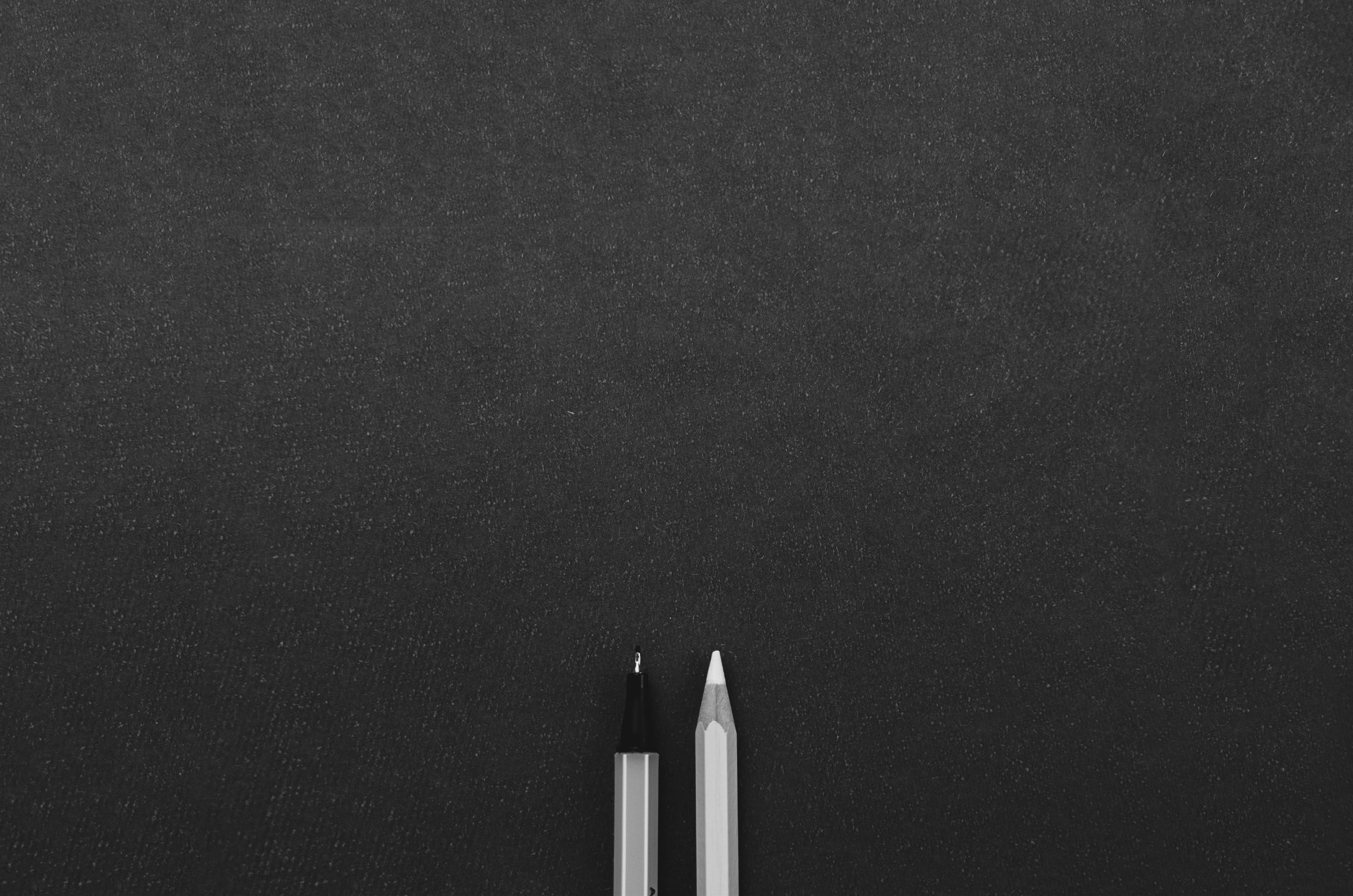 Two pencils on a black background